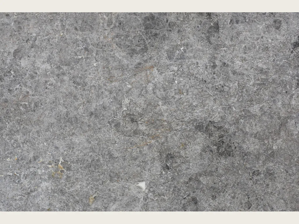Slab of gray Tundra marble: cloudy medium gray with diffuse patches and light spots