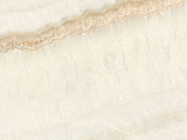 Detail of beige Ivory onyx: soft diagonal bands and the fine honey line over the ivory