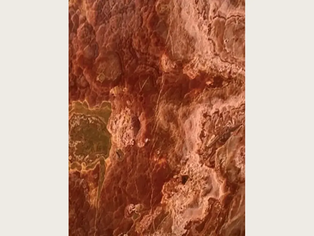Red Onyx slab: rust-red background with irregular dark red and orange spots and a greenish ochre zone