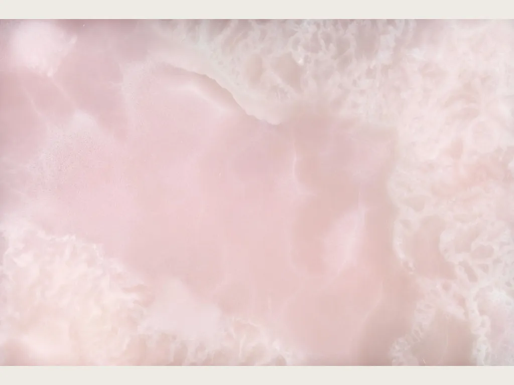 Pink Onyx slab: lilac pink background with white clouds and fine diagonal veins (another slab)