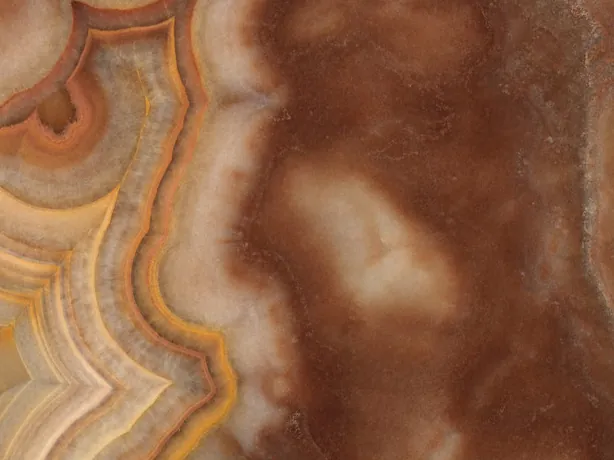 Detail of Sultano brown onyx: wavy orange and cream bands in the foreground