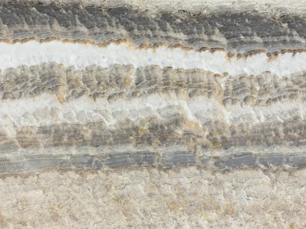 Detail of Velluto gray onyx: dense bands with a wavy edge and the shine of the polish