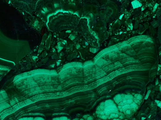 Malachite detail: eye-like circles and green bands with the gloss of the polish
