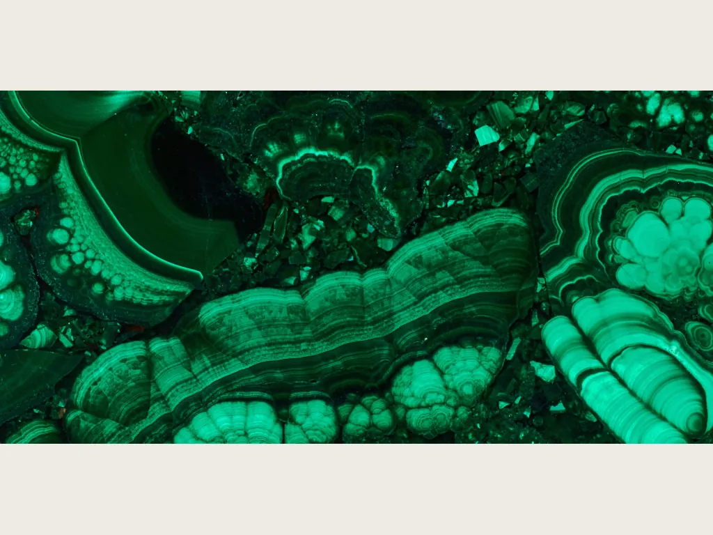 Malachite slab: light and dark green concentric bands with eye-like circles over emerald green