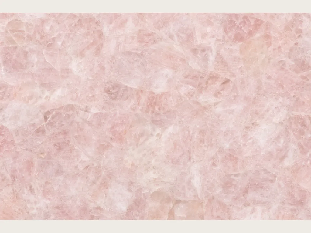 Slab of rose quartz: pink and white glassy fragments on a pale pink background