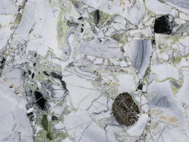 White Beauty slab detail: a light green matrix and fine gray lines between polished fragments