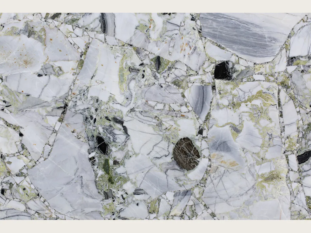 White Beauty slab: white and gray fragments joined by a light green matrix with black pieces