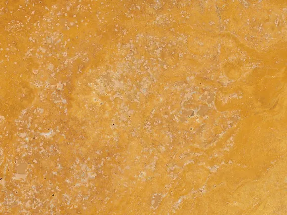 Yellow travertine detail: small pores and clouds of tone over the golden background