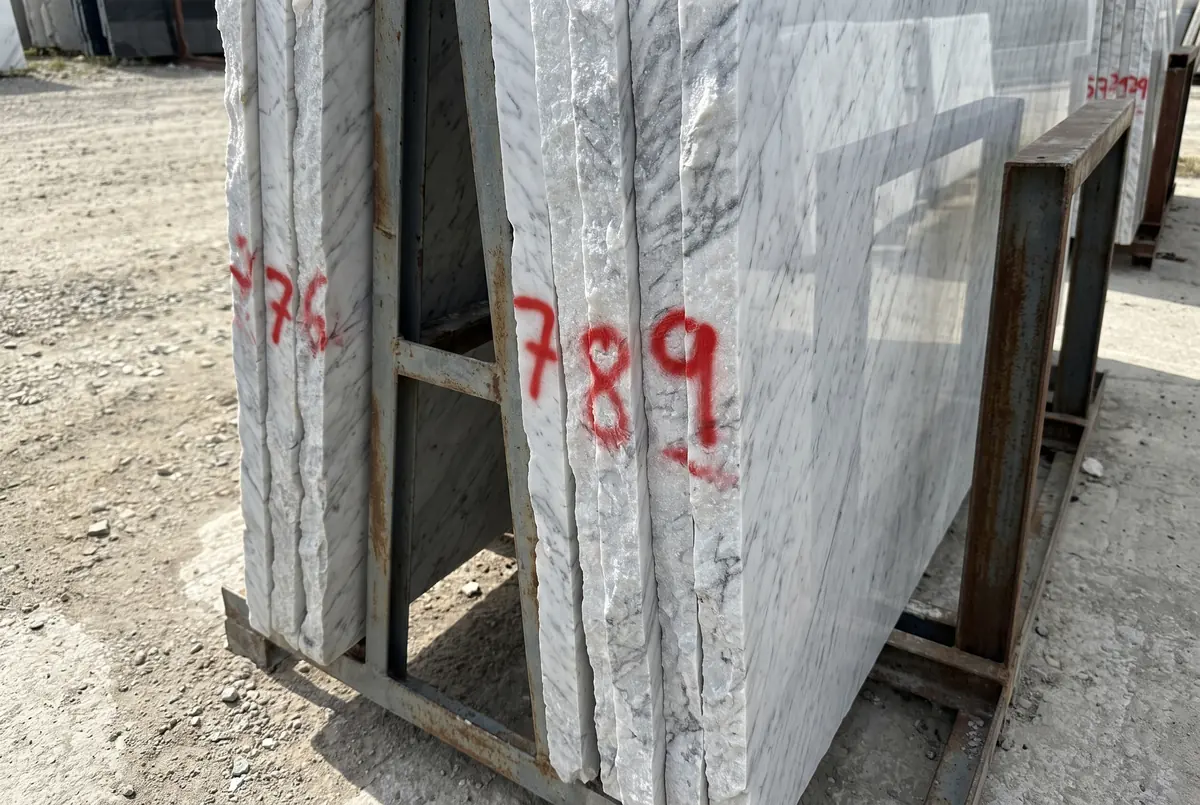 Marble slab edges with hand-painted numbers at the producer's yard