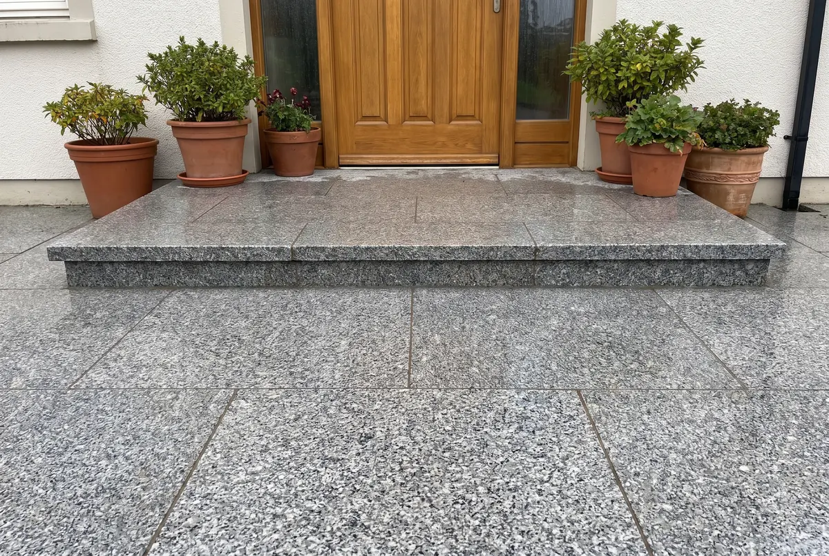 House entrance with steps and an outdoor floor of flamed gray granite