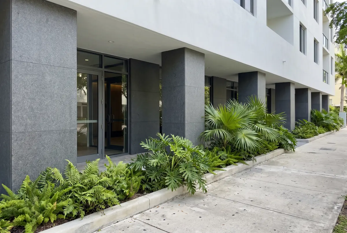 Ground floor of a building with columns and a facade base clad in dark gray granite