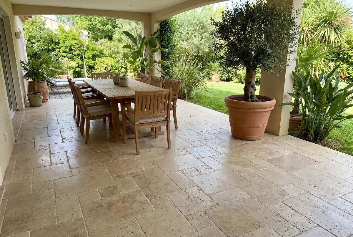 Terrace floor and pool coping in beige Roman travertine: light grayish beige with many open holes of different sizes